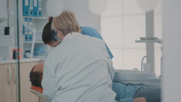 Dişi ağrıyan adama cerrahi işlem yapan uzmanlardan oluşan bir ekip. — Stok video