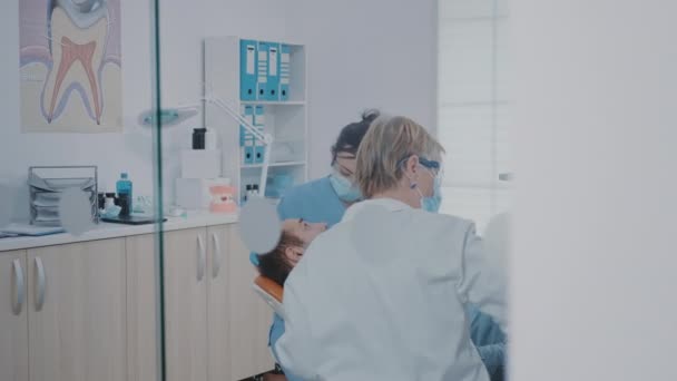 Fogászati beavatkozást végző fogászati csoport a betegen — Stock videók