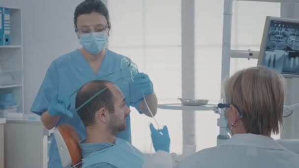 Oral bakım çalışanı hastaya anestezi ile oksijen maskesi veriyor. — Stok video
