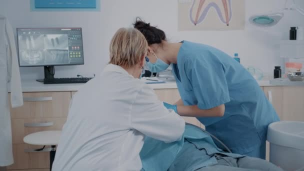 Estomatologista e enfermeiro fazendo procedimento de extração no paciente — Vídeo de Stock