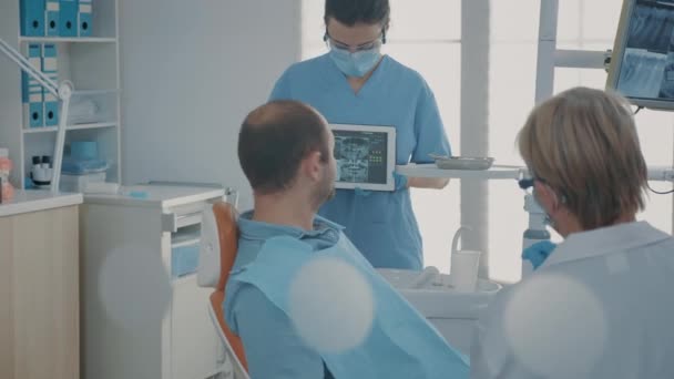 牙科助理持有带牙齿X光扫描的数码平板电脑 — 图库视频影像