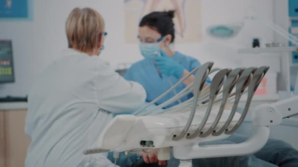 Zubní tým vyšetřuje pacienta ve stomatologické kabinetě — Stock video