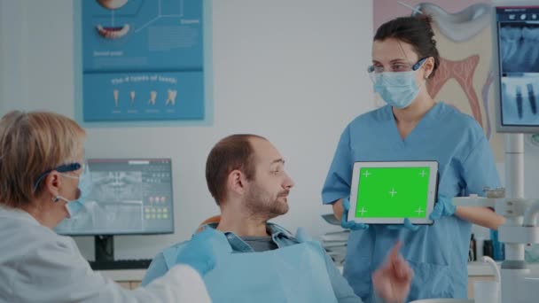 Patiënt en tandheelkunde team op zoek naar tablet met groen scherm — Stockvideo