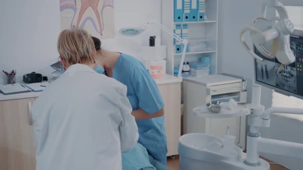 歯肉組織学キャビネットで歯の抽出を行う歯科チーム — ストック動画
