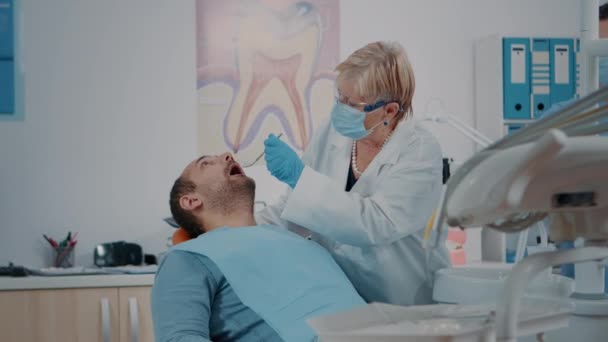 Patient öffnet Mund und Zahnarzt untersucht Gebiss-Arbeit — Stockvideo