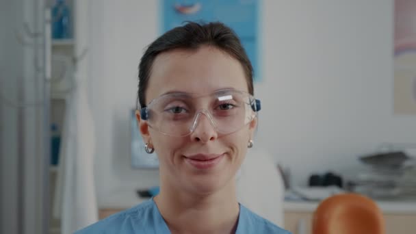 Portret van een assistent met een beschermende bril in een kliniek voor mondverzorging — Stockvideo