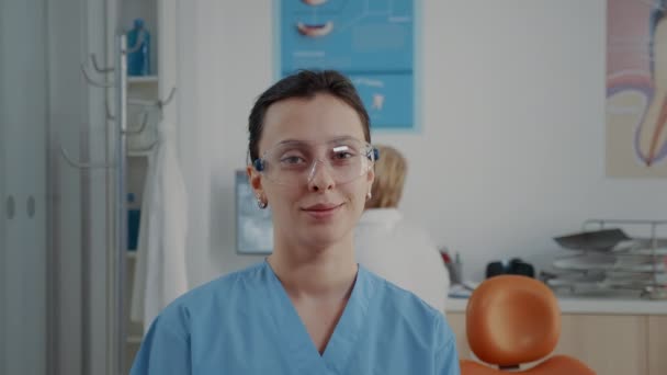 Портрет ортодонтической медсестры, смотрящей в камеру в стоматологическом кабинете — стоковое видео