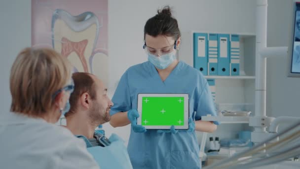 Verpleegkundige en patiënt analyseren van groen scherm op digitale tablet — Stockvideo