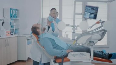 Stomatolog, kabinde ağzı açık hastayı muayene ediyor.