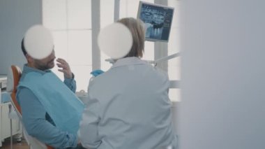 Dijital tabletteki takma diş röntgenini gösteren diş hekimi