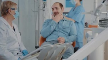 Stomatolog diş hekimliği bürosunda bakımı sorunlu bir hastaya danışmanlık yapıyor.