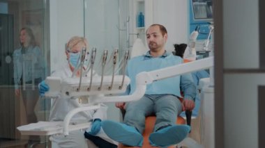 Stomatolog ortodontik aletlerle diş muayenesi yapıyor.