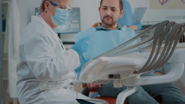 Dentista maduro examinando paciente con caries y dolor de muelas — Vídeos de Stock