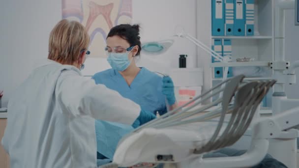 Команда фахівців, що консультують пацієнта з зубним болем — стокове відео