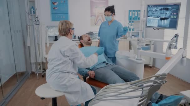 Dentista e assistente fazendo consulta com ferramentas odontológicas — Vídeo de Stock