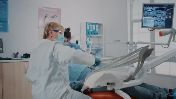 Woman dentist using instrument to do drill procedure — Video Stock