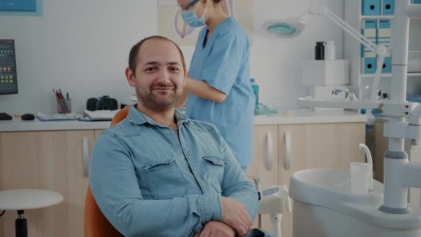 Portret van een patiënt in een tandartsstoel in een kliniek voor mondverzorging — Stockvideo