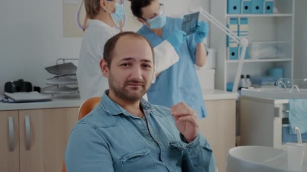 Portrait of patient with toothache looking at camera in dentistry office — Stockvideo
