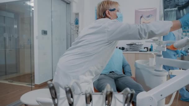 Stomatologue utilisant le moniteur pour montrer l'examen radiographique de prothèse dentaire à l'homme — Video