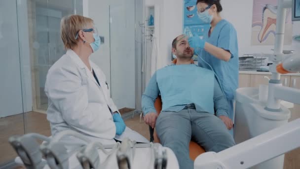 Asistente de odontología poniendo máscara de oxígeno en la cara del paciente — Vídeos de Stock