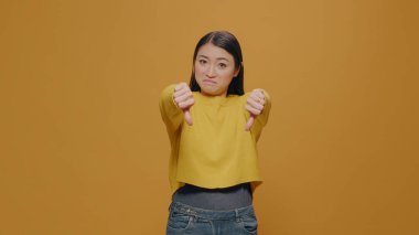 Stüdyoda kamerada hoşnutsuz bir kadının baş parmağını göstermesi