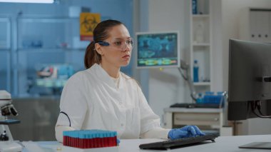 Bilim laboratuarında bilgisayar üzerinde çalışan bir araştırmacının portresi