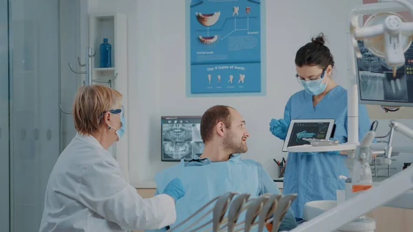 Dentistry team explaining radiography to sick patient — Stock Photo, Image