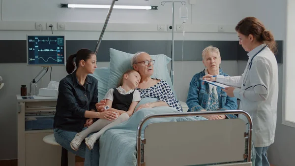 Little girl and mother visiting grandpa in hospital ward — Stockfoto