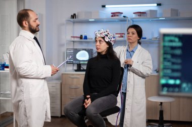 Kadın hastayla nöroloji hastalığı belirtilerini tartışan bilim adamı doktor.