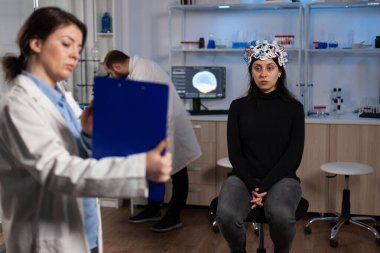 Uzman nörolog elinde tomografi bilgisi olan bir pano tutuyor.