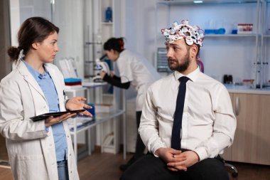 Nörolog kadın doktor tablet bilgisayarında nörolojik hastalık belirtileri yazıyor.