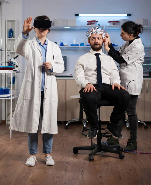 Chercheuse portant un casque de réalité virtuelle lors d'une expérience neurologique — Photo