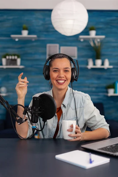 Portrait of happy woman facing camera recording in home studio. — стоковое фото