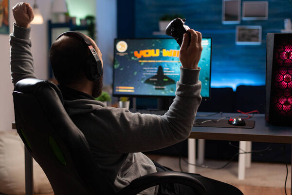Man winning video games with joystick and headphones