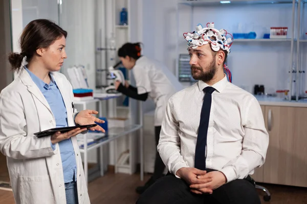 Neurologue femme médecin tapant les symptômes de la maladie neurologique sur tablette — Photo