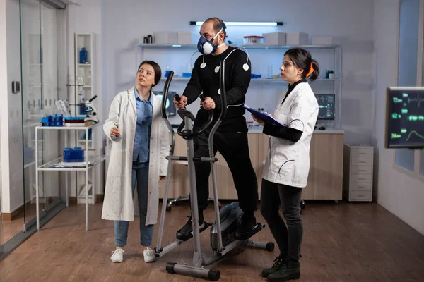 Klinik antreman sırasında sporcunun vücut dayanıklılığını analiz eden doktor ekibi. — Stok fotoğraf