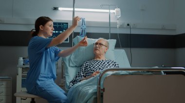 Hasta yaşlı adam hastane koğuşunda röntgen sonuçları alıyor.