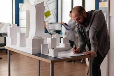Konut projesinin inşaat planı hakkında notlar alan geliştirme mühendisi