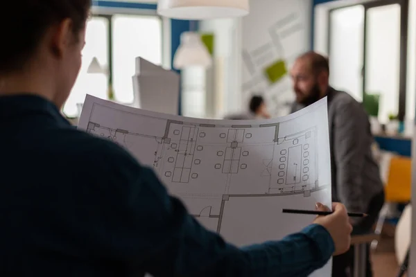 Primer plano del arquitecto en la oficina de arquitectura sosteniendo lápiz y planos —  Fotos de Stock