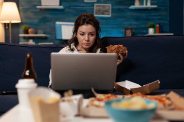 Sosyal medyayı kontrol eden nüfuzlu biri lezzetli bir hamburger ve fast food servis menüsü yiyor.