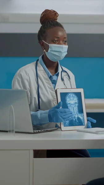 Młody medyk pokazujący nowoczesną tabletkę ze skanowaniem rentgenowskim — Zdjęcie stockowe
