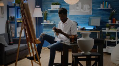 Zeki telefonlu siyahi genç sanatçı ilham arıyor