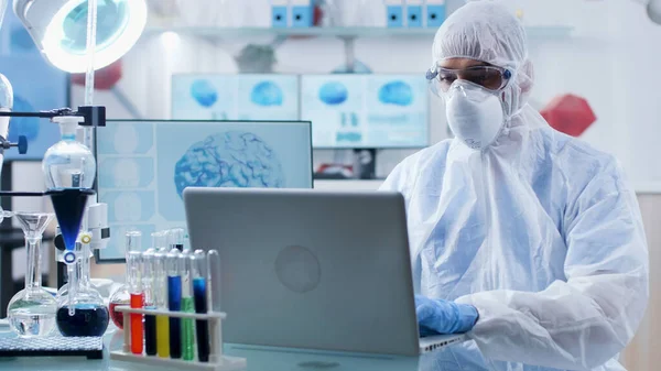 Ученый-химик, доктор с аппаратурой ppe, анализирующий образец ДНК, печатающий медицинскую диагностику — стоковое фото