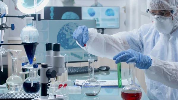 Médico cientista vestindo equipamentos ppe fazendo experiência química usando óculos médicos transparentes — Fotografia de Stock