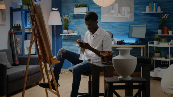 Zeki telefonlu siyahi genç sanatçı ilham arıyor