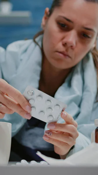 Женщина с холодным взглядом на таблетки с капсулами и бутылки с таблетками — стоковое фото