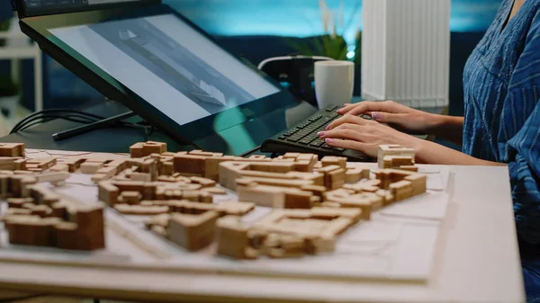 Närbild av byggmodell på bord och kvinna med pekskärm — Stockfoto