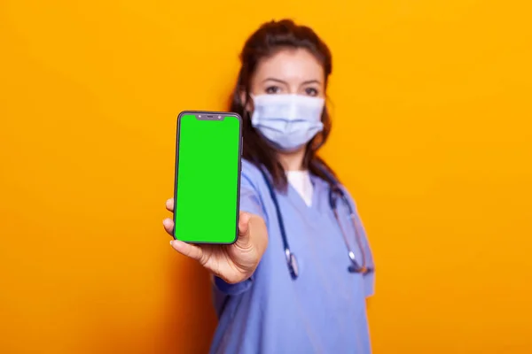스마트폰에 녹색 스크린을 들고 있는 간호사 — 스톡 사진