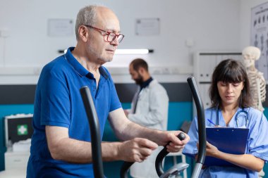 Hemşire yaşlı adama tıbbi tedavi için destek veriyor.