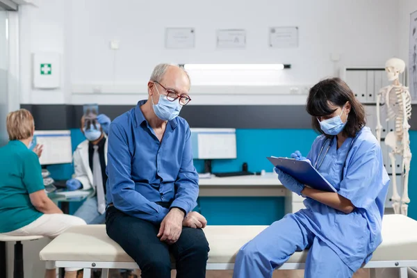 Nurse and patient with face masks doing consultation — Stock Photo, Image